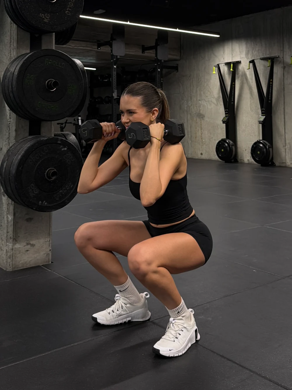 Coach doing a squat with dumbbells